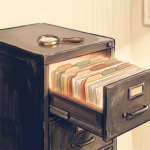 Open vintage filing cabinet drawer with tabbed folders and a magnifying glass on top, illustrated in warm muted tones.